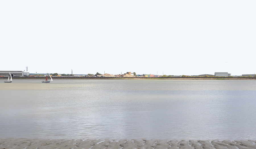 landscape photo with sailboats on stretch of water and light industrial structures on an island