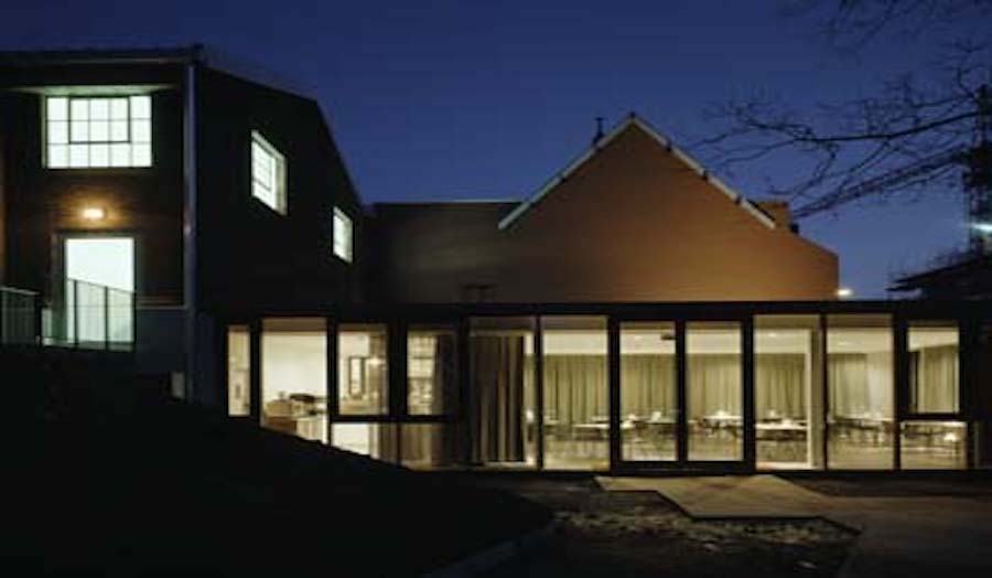 photo of 2 storey building at dusk with well-lit interiors seen through large windows