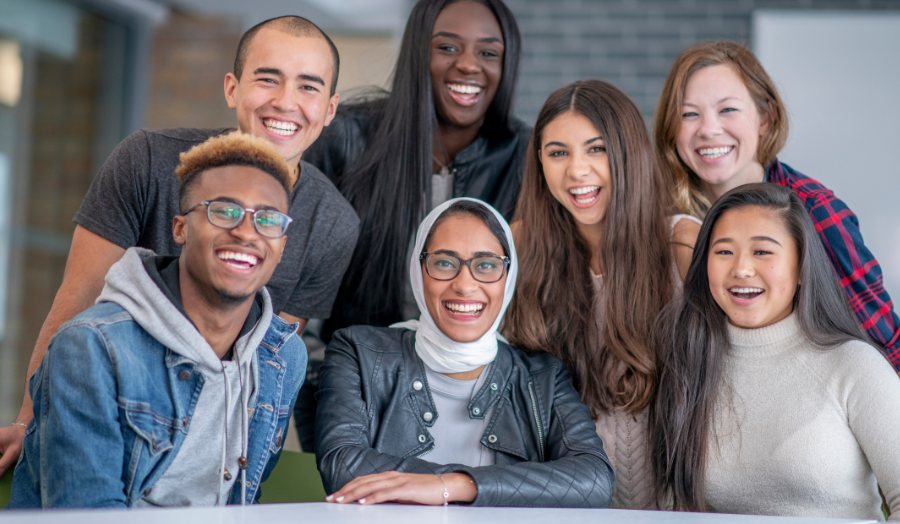 A group of diverse students are looking straight at the camera lens.